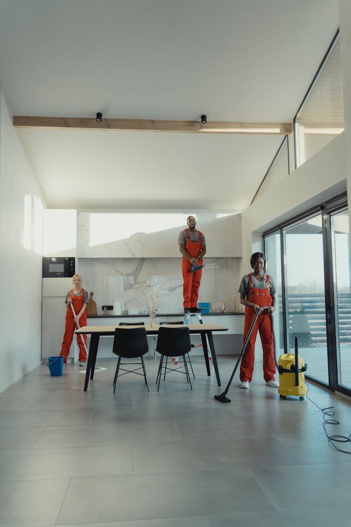 services-02 Team of professional cleaners working in a spacious, modern indoor setting.